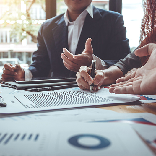 BUSINESS-people-talking-at-conference-table-with-charts