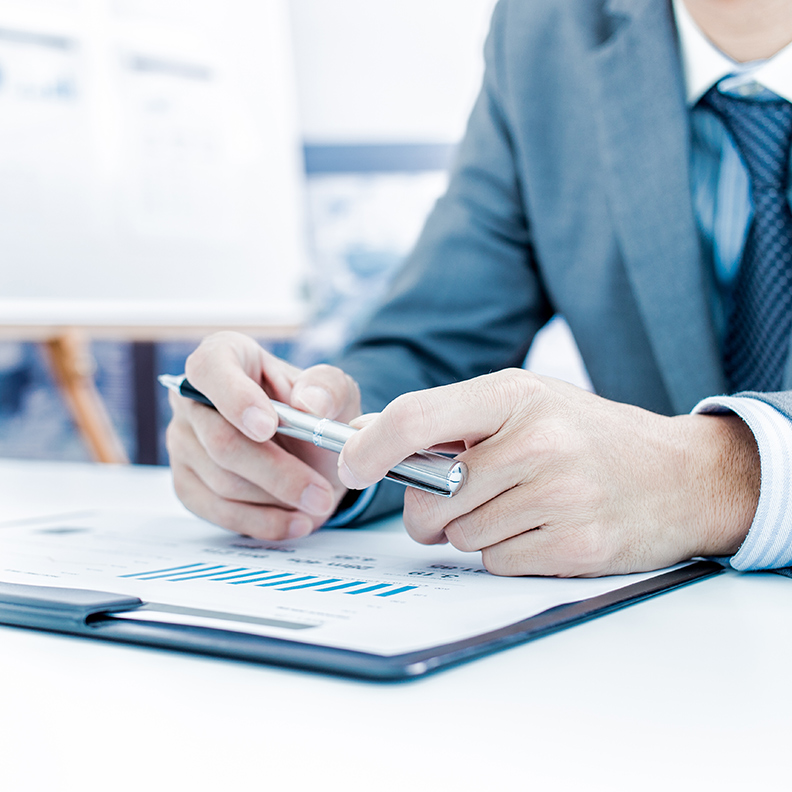 INSIGHT IMAGE / WEALTH man-in-suit-holding-pen-over-laptop 792x792