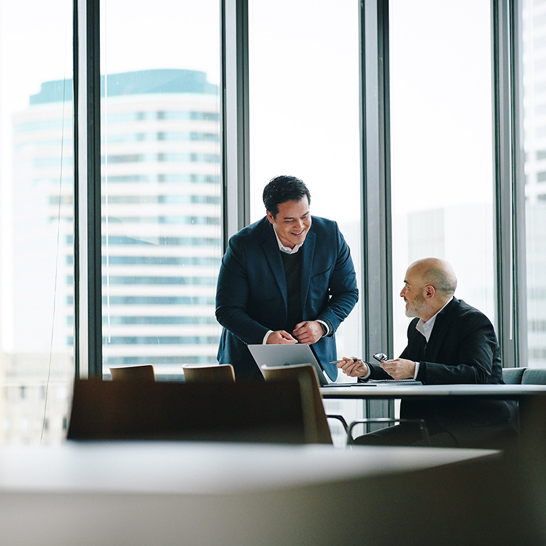 INSIGHT IMAGE / BUSINESS two men talking at conference table downtown city 792x792